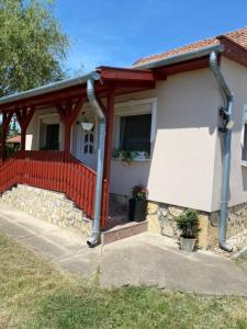 a small house with a red fence in front of it at Magic Vendégház in Abádszalók