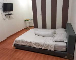 ein Bett mit zwei Kissen auf einem Zimmer in der Unterkunft KoolKost @ Tarahan Lampung (Minimum Stay 30 Nights) in Blimbing