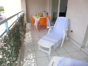 d'un balcon avec une table et des chaises. dans l'établissement Apartment Le Clos Saint Saens-1 by Interhome, à Saint-Aygulf