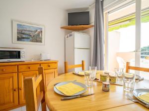 eine Küche mit einem Holztisch und eine Küche mit einem Kühlschrank in der Unterkunft Apartment Les Rives du Lac-7 by Interhome in Le Grau-du-Roi