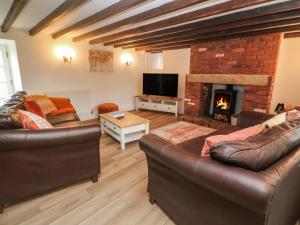 a living room with two couches and a fireplace at Trevedran Cottage in Penzance