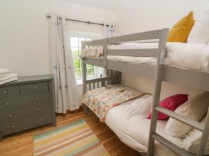 sypialnia z 2 łóżkami piętrowymi i komodą w obiekcie Trevedran Cottage w mieście Penzance
