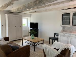 a living room with a couch and a table at L Ostal in Trélissac