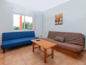 a living room with a blue couch and a table at Villa Villa Malva II by Interhome in Les tres Cales