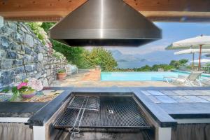 a barbecue grill with a hood over a pool at Villa Maria Laura in Lierna