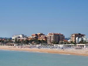 a beach with a bunch of chairs and buildings at B&B Lido Apartament 10B in Civitanova Marche