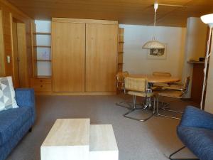 a living room with a blue couch and a table at Apartment Kronenplatz 6 # 2 by Interhome in Lenk