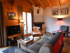 a living room with a couch and a tv at Chalet Ropiar by Interhome in Ovronnaz