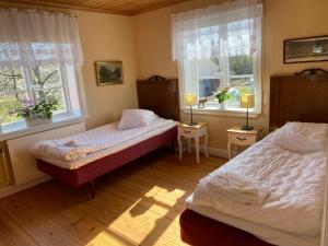 um quarto com 2 camas e 2 janelas em Spjutsbygds Gårds Bed and Breakfast em Rödeby