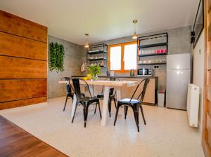 a kitchen with a table and chairs and a refrigerator at Atlas Chmur Apartament in Biały Dunajec