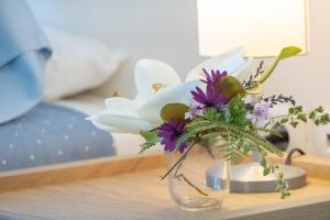 a glass vase filled with flowers on a table at Secluded Beach Apartments in Skala Kefalonias