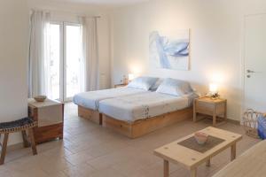 a bedroom with a large bed and a table at Secluded Beach Apartments in Skala Kefalonias