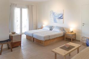 a bedroom with a large bed and a table at Secluded Beach Apartments in Skala