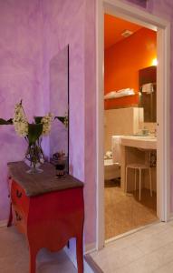 um quarto com paredes roxas e uma mesa com um espelho em 66 Imperial Inn Deluxe B&B em Roma