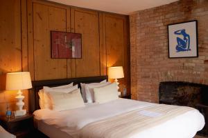 a bedroom with a large bed with a fireplace at The Grosvenor Arms in Hindon