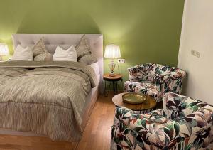 um quarto com uma cama, um sofá e uma cadeira em Hotel Neuhauser em Volkach