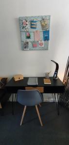 un escritorio negro con una silla azul y una lámpara en L'Appart'Mans -charmant-studio-centre ville-2 pers en Le Mans