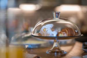 a glass dish with some food on a table at Peruzzi Urban Residences in Florence +111 photos
