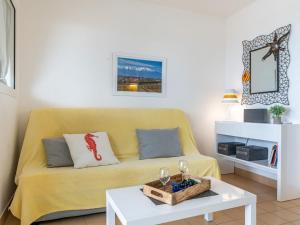 - un salon avec un canapé jaune et une table dans l'établissement Apartment Les Trois Mâts-8 by Interhome, à Canet