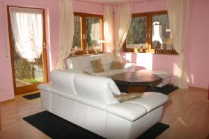 een woonkamer met een witte bank en een tafel bij Ferienwohnung Sabine in Hornberg
