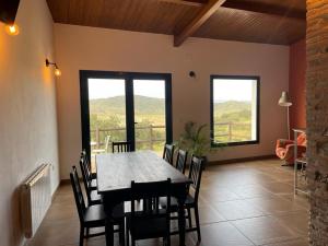 a dining room with a table and chairs and windows at FINCA LAS DEHESILLAS in Monesterio