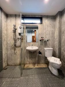 a bathroom with a toilet and a sink at Loft 202 Hotel in Bangkok