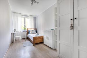 een kleine slaapkamer met een bed en een bureau bij Prime Home PARKOWY in Gdynia