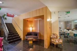vestíbulo con escalera, silla y mesa en Hotel De Cerva en Cerva