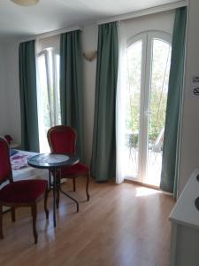 a living room with a table and chairs and a window at Ana Rooms in Krk