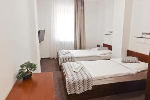 Zimmer mit 2 Betten und einem Tisch in der Unterkunft Hotel Slanica in Námestovo