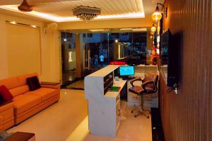 a living room with a couch and a desk at ShriGo Hotel Haridwar in Haridwār