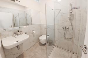 a bathroom with a shower and a sink and a toilet at Hotel Slanica in Námestovo