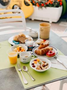 a table topped with plates of breakfast foods and orange juice at Hotel Marina in Lido di Jesolo