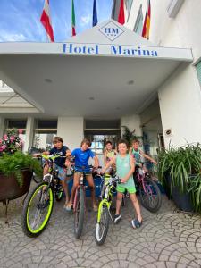 a group of children standing in front of a hotel with their bikes at Hotel Marina in Lido di Jesolo