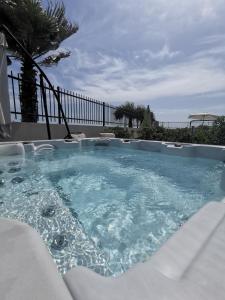 une baignoire jacuzzi avec eau bleue et une clôture dans l'établissement Le Nautilia Résidence de Luxe "réservée aux couples", au Cap d'Agde