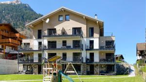 a large house with a playground in front of it at UplandParcs Montafon in Sankt Gallenkirch