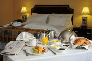 a breakfast table with food on a bed at Park Plaza Santiago in Santiago