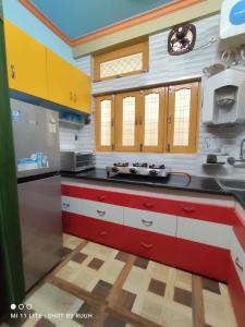 a kitchen with red white and yellow cabinets at Ganga Lakshya Dham in Uttarkāshi