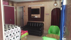 een woonkamer met een bank en een tv bij Ganga Lakshya Dham in Uttarkāshi