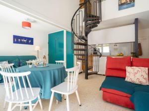 a living room with a table and a spiral staircase at Holiday Home Villas Plein Soleil 1 by Interhome in La Grande Motte