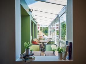a room with a balcony with tables and chairs at Kyriad Rouen Sud - Val de Reuil in Val de Reuil
