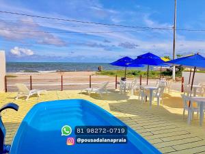 - une piscine à côté d'une plage avec des chaises et des parasols dans l'établissement Pousada Lá Na Praia, à São José da Coroa Grande