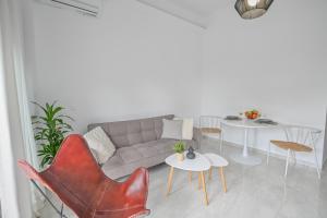 a living room with a couch and tables and chairs at Moka Apartments in Chania Town