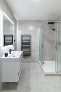 a white bathroom with a shower and a sink at 4 pokoje in Ostrava