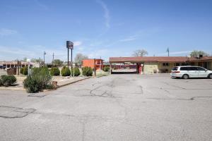 a parking lot with a car parked in front of a building at Route 66 Inn of Santa Rosa, NM in Santa Rosa