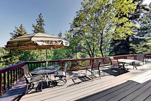 una terraza con mesa, sillas y sombrilla en Timberline Squirrel, en Lake Arrowhead