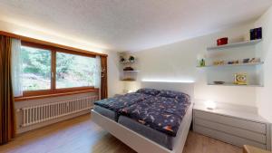 sypialnia z łóżkiem i oknem w obiekcie Funtauna B38 w Sankt Moritz