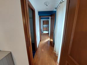 a hallway leading to a room with blue walls and wood floors at Appartamento incantevole in piccola corte a Rho in Rho
