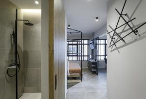 a hallway with a bathroom and a bedroom with a bed at Olvios Lofts @Ladadika in Thessaloniki