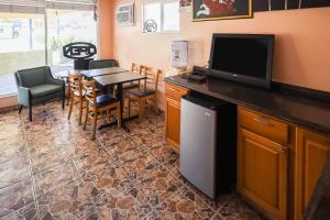 a kitchen with a table and a television and a dining room at Route 66 Inn of Santa Rosa, NM in Santa Rosa